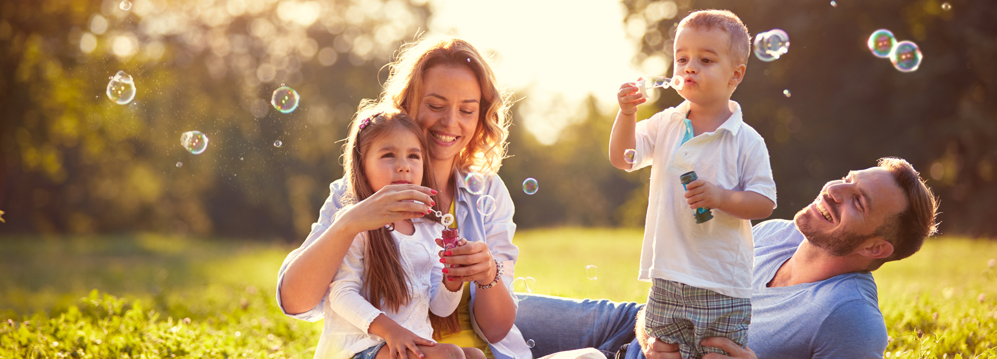Family With Children Blowing Soap Bubbles Outdoor